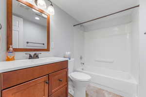 Full bathroom featuring bathing tub / shower combination, vanity, tile patterned flooring, and toilet