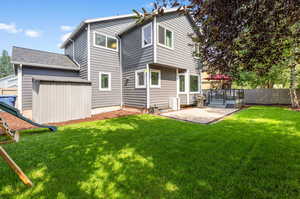 Rear view of property with a patio and a lawn