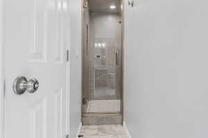 Primary Bathroom with a shower with door and tile patterned flooring