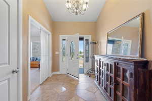 Foyer entrance featuring a notable chandelier and light tile patterned floors