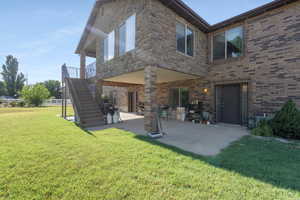 Rear view of house with a patio and a yard