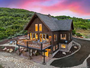 Back house at dusk featuring a wooden deck