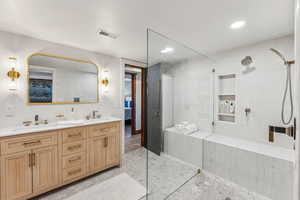 Bathroom with dual vanity, a tile shower, and tile patterned floors