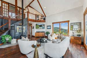 Living room featuring high vaulted ceiling, dark hardwood / wood-style floors, and a wood stove