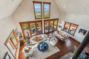 Living room featuring hardwood / wood-style flooring, a mountain view, french doors, and high vaulted ceiling