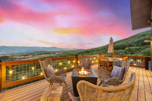 Deck at dusk with a mountain view and an outdoor fire pit