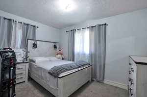 Carpeted bedroom with a textured ceiling