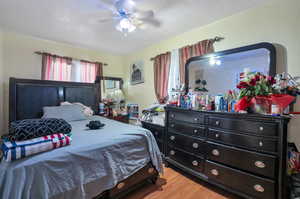 Bedroom with ceiling fan and wood-type flooring