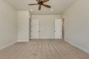 Empty room featuring ceiling fan and light carpet