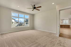 Carpeted spare room with ceiling fan and sink