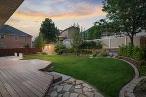 Yard at dusk featuring a storage shed and a deck