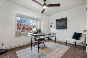 Carpeted office featuring ceiling fan