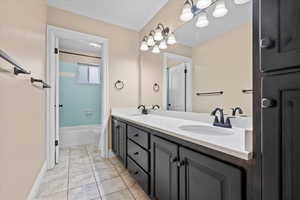 Full bathroom with tiled shower / bath, and double vanity