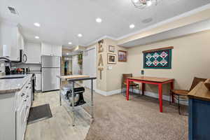 basement apartment: Kitchen featuring crown molding, sink, light stone counters, new appliances with stainless steel finishes, and light hardwood / wood-style flooring