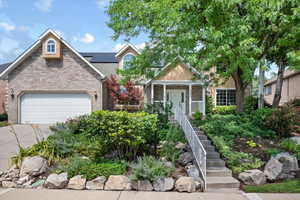 View of front of property with a garage and solar panels