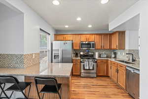 Kitchen with Breakfast bar and stainless steel appliances including a gas stove.