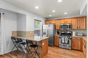 Kitchen with Breakfast bar and stainless steel appliances including a gas stove.