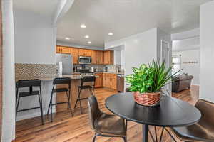 Dining space with sink, light wood-type flooring, and a textured ceiling