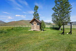 View of yard featuring a mountain view, a storage shed, and a rural view