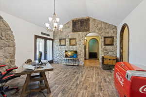 Dining room featuring hardwood / wood-style flooring, lofted ceiling, and a chandelier