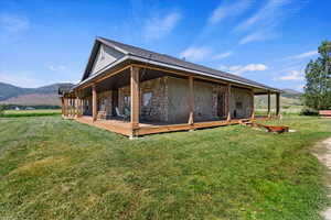 Rear view of property with a lawn and a mountain view