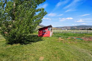 View of yard featuring a storage unit, a rural view, and a mountain view