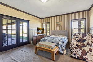 Carpeted bedroom with access to outside, french doors, and ornamental molding