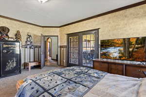 Bedroom featuring crown molding, carpet, and french doors