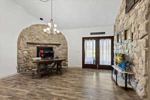 Entryway featuring vaulted ceiling, french doors, an inviting chandelier, and hardwood / wood-style floors