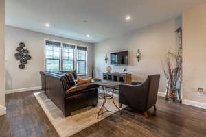 Living room with dark wood-type flooring