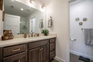 Bathroom featuring vanity, walk in shower, and tile patterned flooring