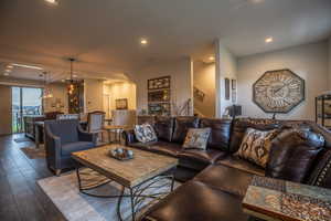 Living room featuring dark wood-type flooring and a notable chandelier