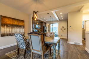 Dining space with dark hardwood / wood-style flooring and beam ceiling