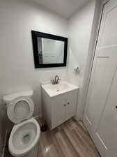 Bathroom featuring toilet, hardwood / wood-style floors, and vanity