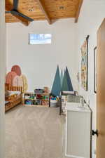 Game room with beamed ceiling, carpet, ceiling fan, and wooden ceiling
