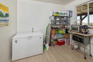 Clothes washing area featuring light wood-type flooring
