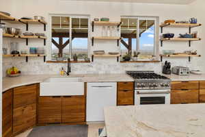 Kitchen featuring gas range, decorative backsplash, and plenty of natural light