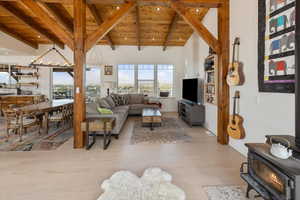 Living room with beam ceiling, light hardwood / wood-style floors, and wood ceiling