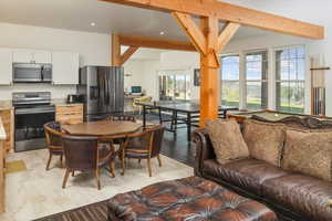 Living room featuring beamed ceiling and light tile patterned floors