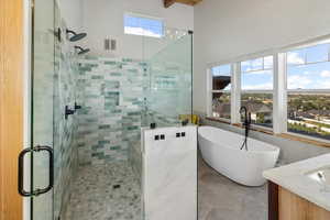 Bathroom with vanity, shower with separate bathtub, tile patterned floors, and tile walls