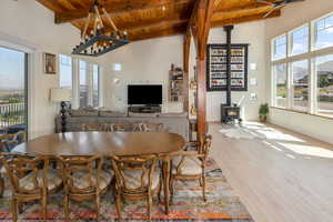Dining room with hardwood floors, a wood stove, lofted ceiling with beams, and cedar wood ceiling
