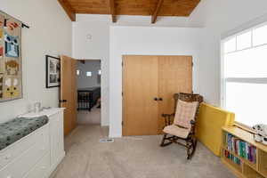 Sitting room with beamed ceiling, light colored carpet, and wood ceiling