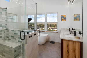Bathroom featuring independent shower and bath, tile patterned flooring, tile walls, and double sink vanity