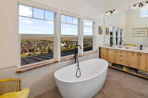 Bathroom featuring dual vanity, a bathing tub, and tile patterned flooring