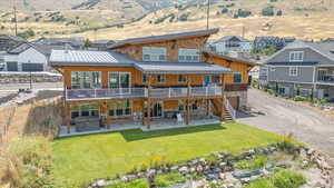 Rear view of house featuring a patio and a lawn