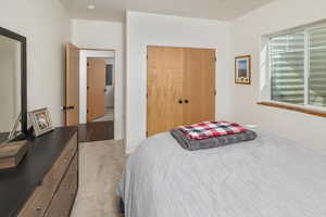 Bedroom with light carpet and a closet