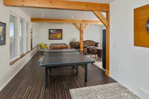 Game room with beam ceiling and dark hardwood / wood-style flooring