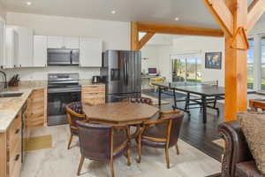 Kitchen with plenty of natural light, light wood-type flooring, stainless steel appliances, and light stone countertops