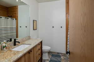 Bathroom featuring vanity, tile patterned flooring, and toilet