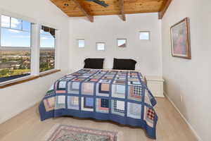 Bedroom featuring wooden ceiling, hardwood / wood-style floors, and beam ceiling